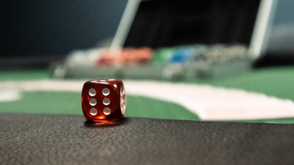 A close-up of a red dice on a casino table, evoking a sense of gambling excitement.